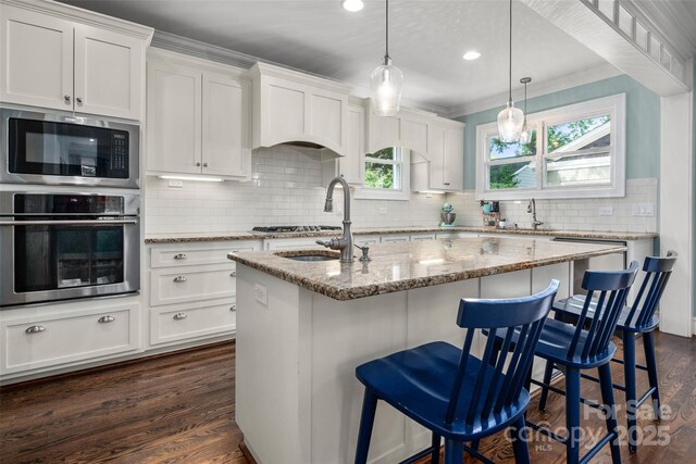 kitchen featuring appliances with stainless steel finishes, dark wood-type flooring, backsplash, white cabinetry, and recessed lighting