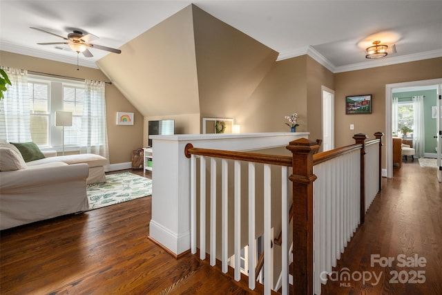 corridor with dark wood finished floors, healthy amount of natural light, an upstairs landing, baseboards, and ornamental molding