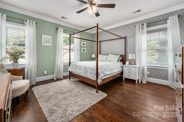 bedroom with crown molding, multiple windows, baseboards, wood finished floors, and wallpapered walls