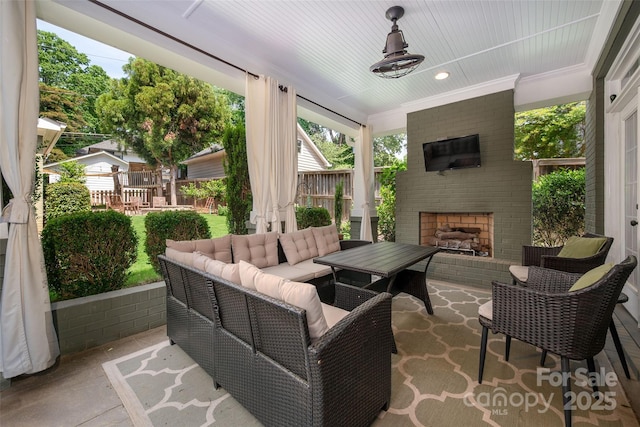 view of patio / terrace featuring an outdoor living space with a fireplace and fence