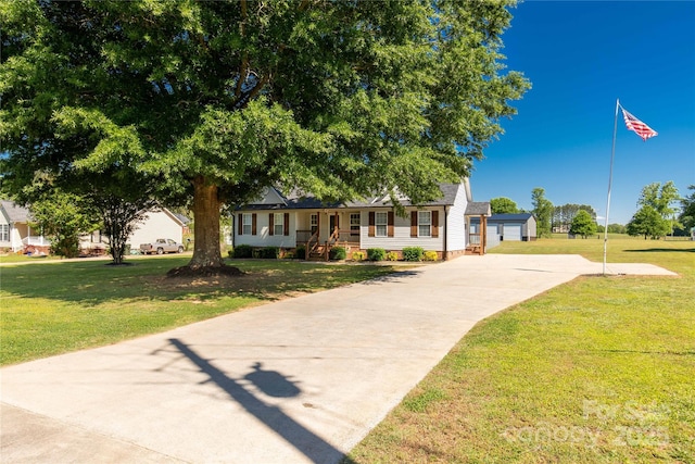 view of front of house with driveway, a front yard, and covered porch