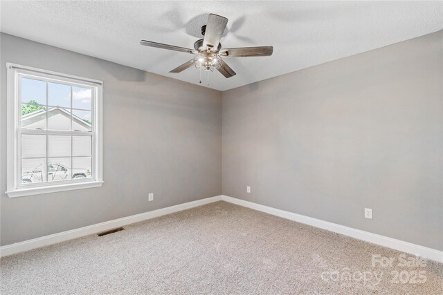 unfurnished room with ceiling fan, carpet flooring, baseboards, and a textured ceiling