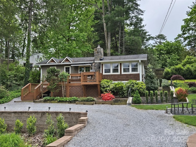 rear view of house featuring a chimney, a deck, and stairway