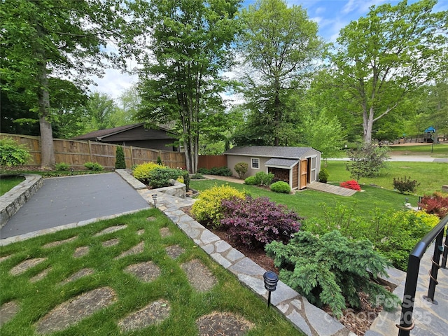 view of yard featuring fence and an outbuilding