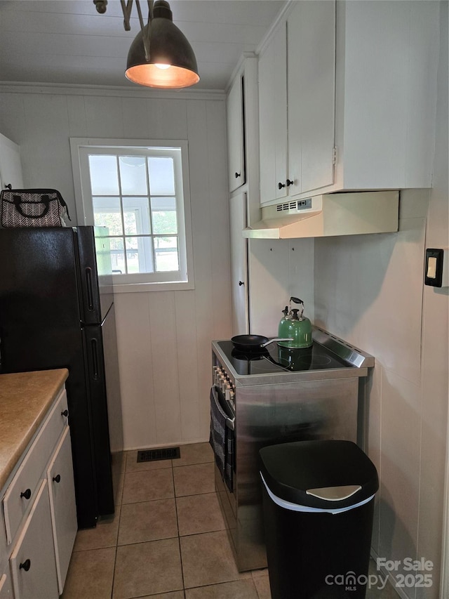 kitchen featuring freestanding refrigerator, range, visible vents, and white cabinets