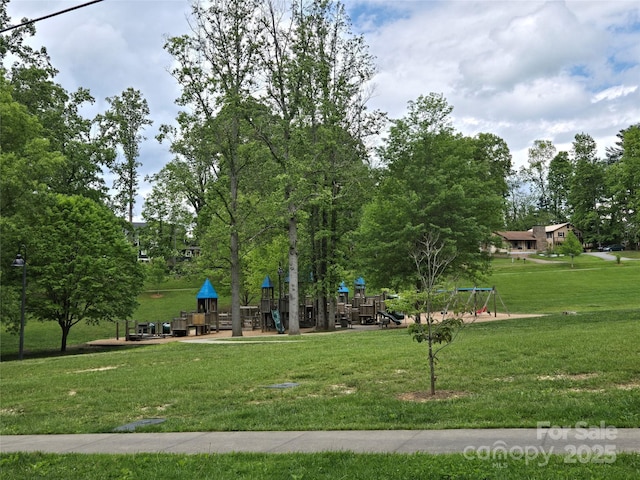 view of property's community with playground community and a yard