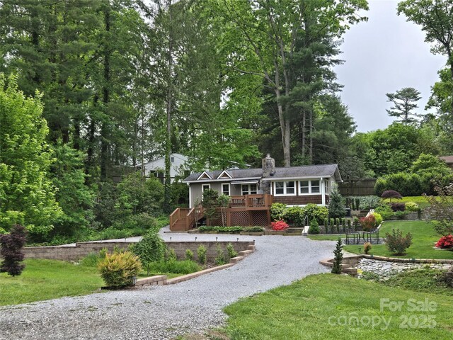 132 Sycamore Ter, Arden, NC 28704 - view of front of property featuring gravel driveway, a deck, a chimney, and a front lawn