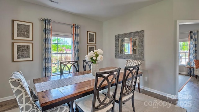 dining area featuring a wealth of natural light, visible vents, wood finished floors, and baseboards