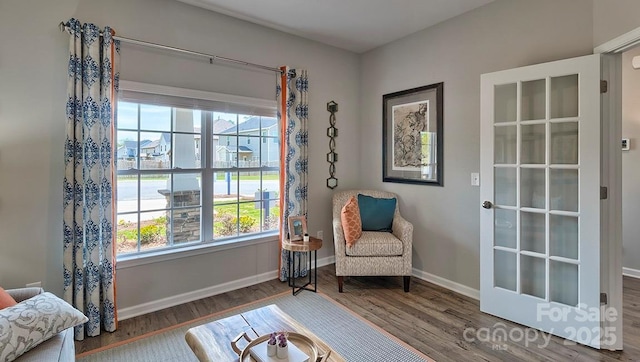 living area with baseboards and wood finished floors
