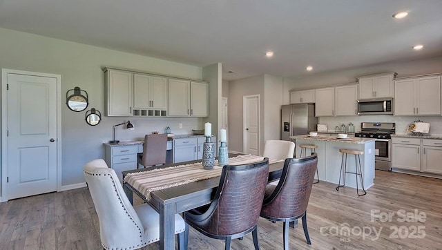 dining space with baseboards, light wood-style floors, and recessed lighting