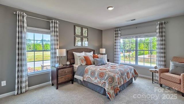 bedroom with baseboards, multiple windows, visible vents, and carpet floors