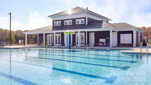 pool with french doors and fence