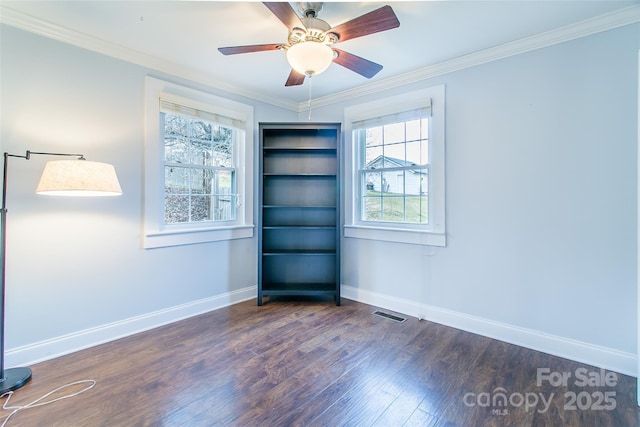 spare room featuring wood finished floors, plenty of natural light, baseboards, ornamental molding, and a ceiling fan