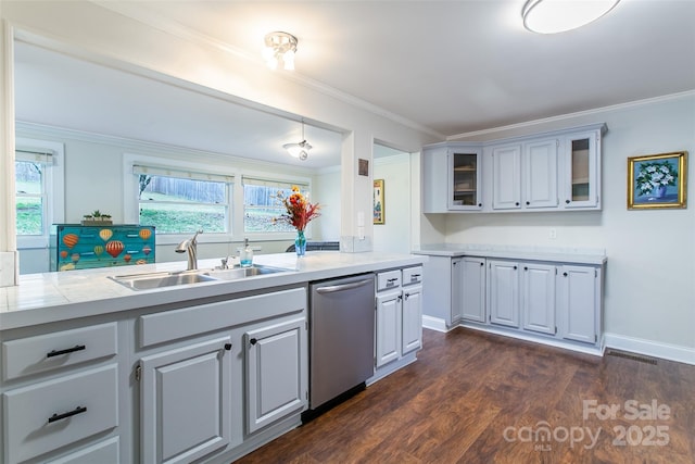 kitchen featuring stainless steel dishwasher, a sink, light countertops, glass insert cabinets, and dark wood-type flooring