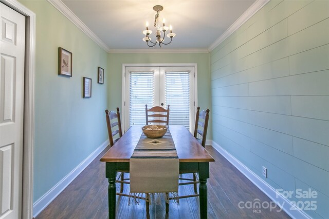 dining room featuring a chandelier, crown molding, dark wood finished floors, and baseboards