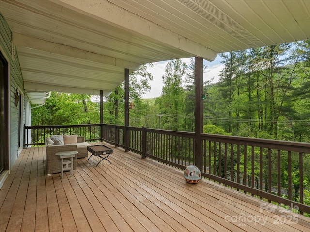 wooden deck featuring an outdoor hangout area and a forest view