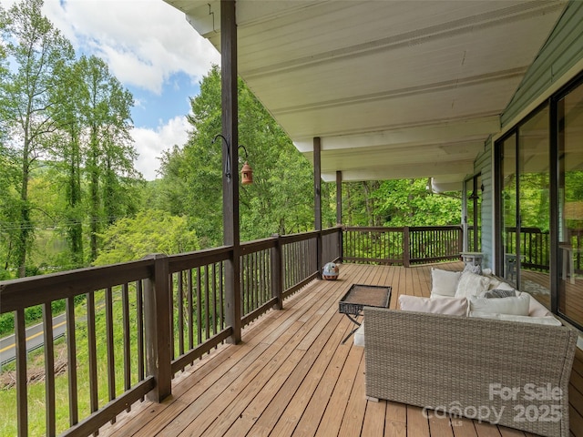 wooden terrace with an outdoor living space