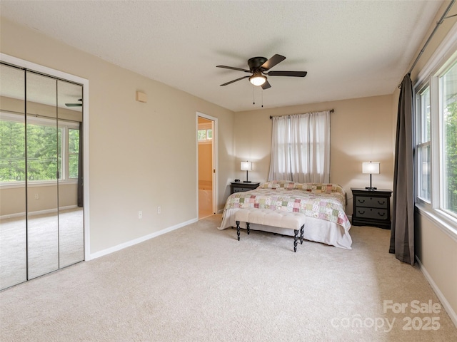 bedroom with carpet flooring, baseboards, a closet, and a ceiling fan
