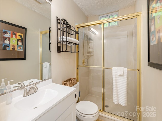 full bathroom featuring a textured ceiling, a stall shower, toilet, and vanity