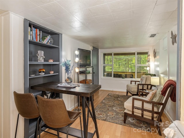 office area featuring wood finished floors and built in shelves