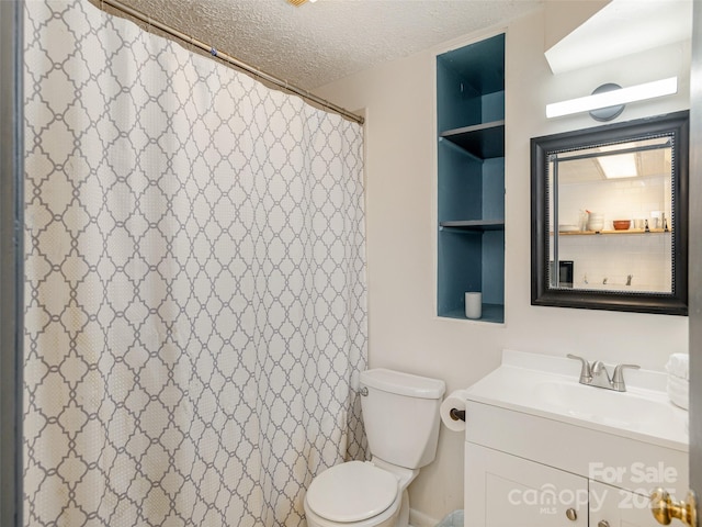bathroom featuring a textured ceiling, vanity, toilet, and a shower with curtain