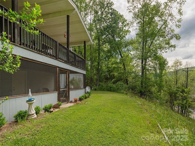 view of grassy yard featuring a sunroom
