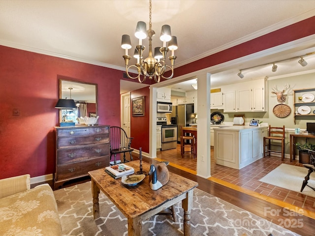 living room with a chandelier, crown molding, and baseboards