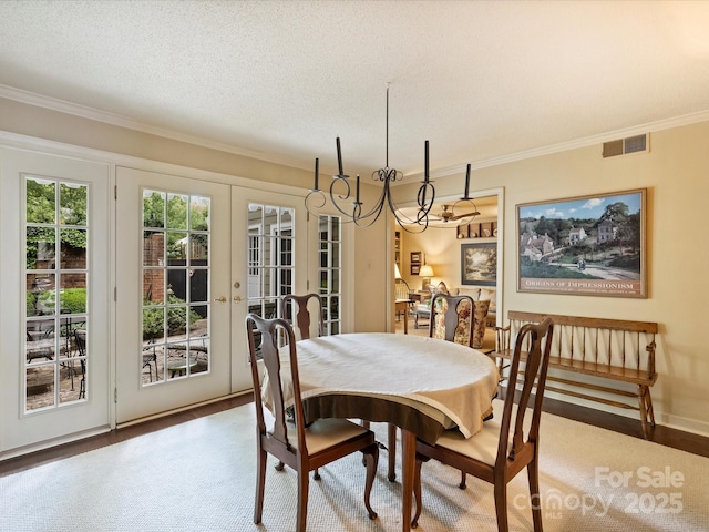 dining room featuring french doors, ornamental molding, and a textured ceiling
