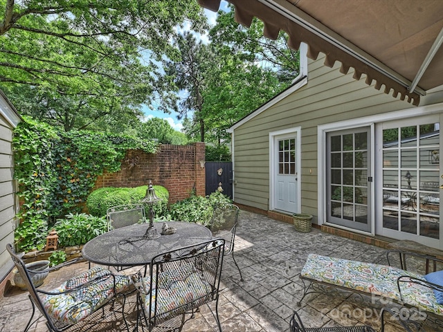 view of patio featuring outdoor dining area and fence