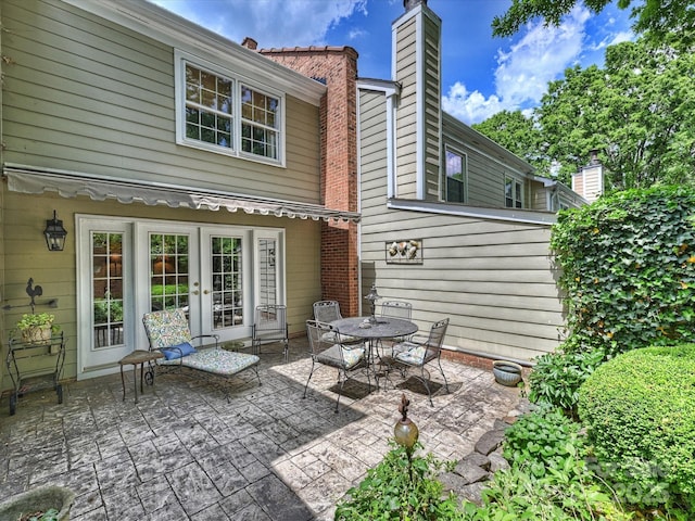 back of house with a patio area, a chimney, and french doors
