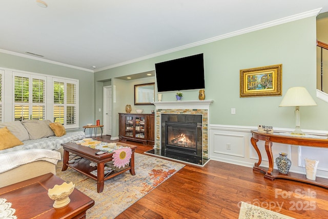2035 Moultrie Ct, Fort Mill, SC 29707 - living area with crown molding, wood finished floors, a glass covered fireplace, and wainscoting