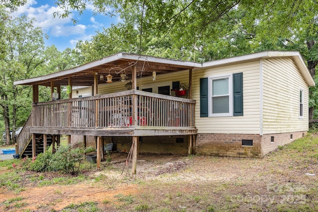 back of property featuring crawl space and a deck