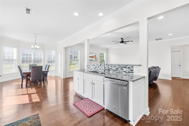 kitchen featuring dishwasher, a sink, a chandelier, ornamental molding, and light stone counters