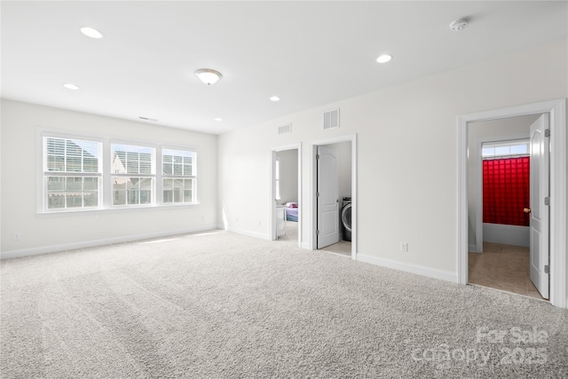 unfurnished bedroom featuring light colored carpet, baseboards, recessed lighting, and washer / clothes dryer