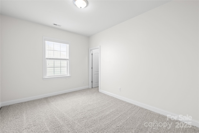 carpeted spare room featuring baseboards