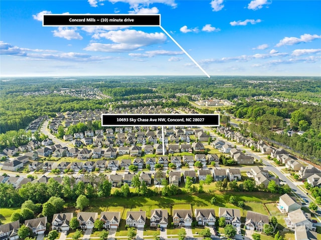 view of property location with a forest and nearby suburban area