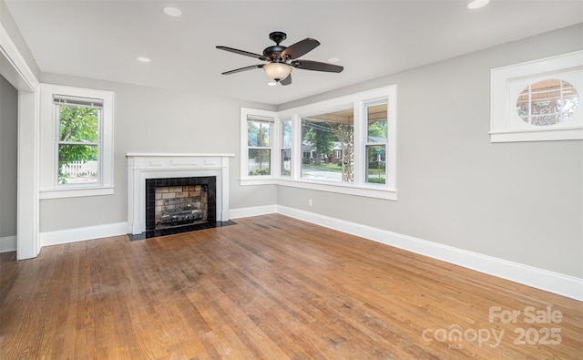 506 7th St SW, Hickory, NC 28602 - unfurnished living room with a fireplace with flush hearth, baseboards, recessed lighting, wood finished floors, and a ceiling fan