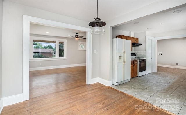 506 7th St SW, Hickory, NC 28602 - kitchen with white appliances, under cabinet range hood, brown cabinetry, tasteful backsplash, and hanging light fixtures