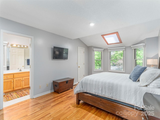 bedroom with lofted ceiling, multiple windows, light wood-style floors, and baseboards