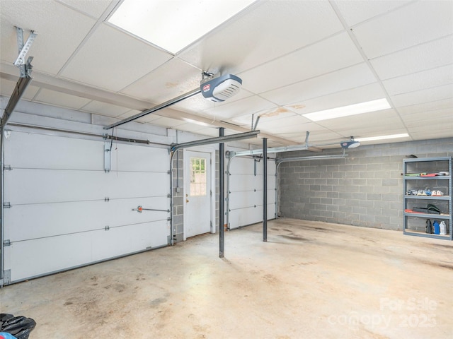garage with concrete block wall and a garage door opener