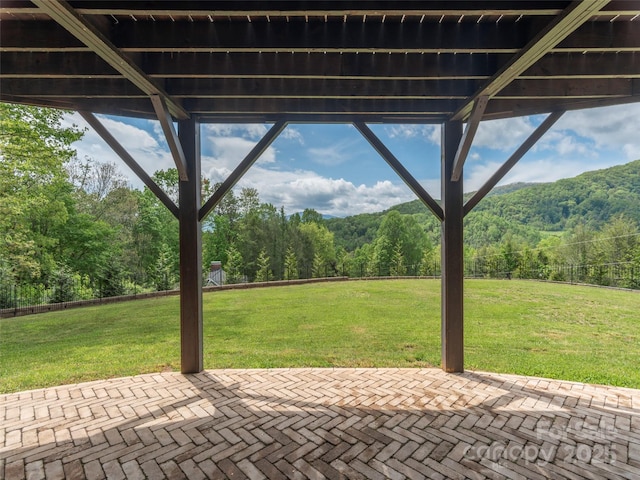 view of patio / terrace with a wooded view and a mountain view