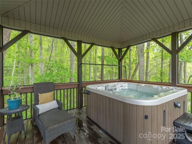sunroom / solarium with a forest view and a jacuzzi