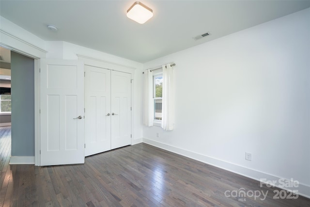21 Bryant St, Asheville, NC 28806 - unfurnished bedroom featuring dark wood finished floors, baseboards, and a closet