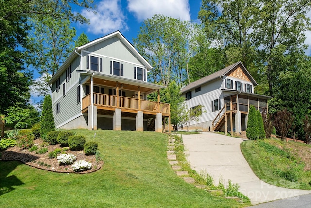 21 Bryant St, Asheville, NC 28806 - view of front of house with board and batten siding, concrete driveway, a front lawn, stairway, and a wooden deck