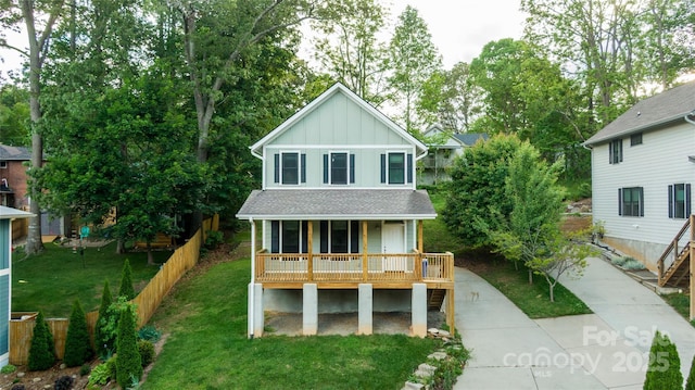 21 Bryant St, Asheville, NC 28806 - view of front of house with board and batten siding, covered porch, and a front lawn