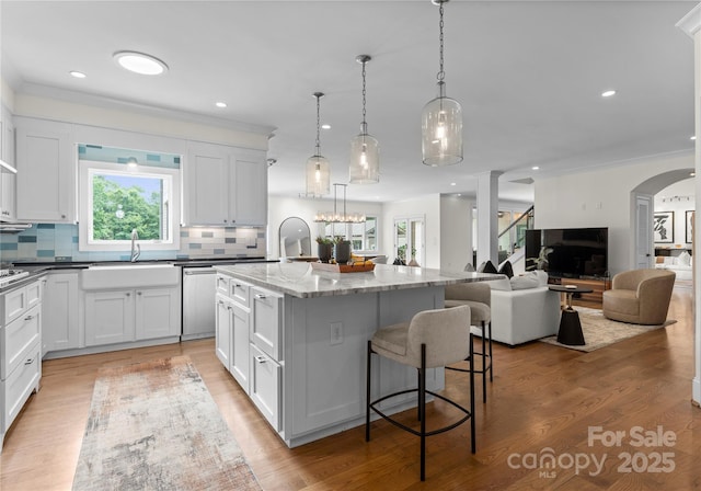 8300 Fairview Rd, Charlotte, NC 28226 - kitchen with a sink, plenty of natural light, an island with sink, backsplash, and ornamental molding