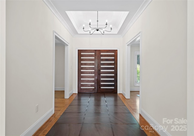8300 Fairview Rd, Charlotte, NC 28226 - entryway with a chandelier, a tray ceiling, baseboards, crown molding, and wood finished floors