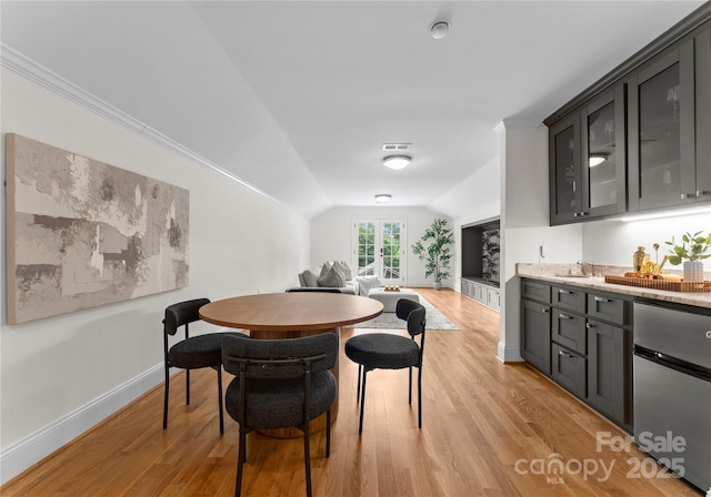 8300 Fairview Rd, Charlotte, NC 28226 - dining area featuring light wood-style floors, vaulted ceiling, baseboards, and bar