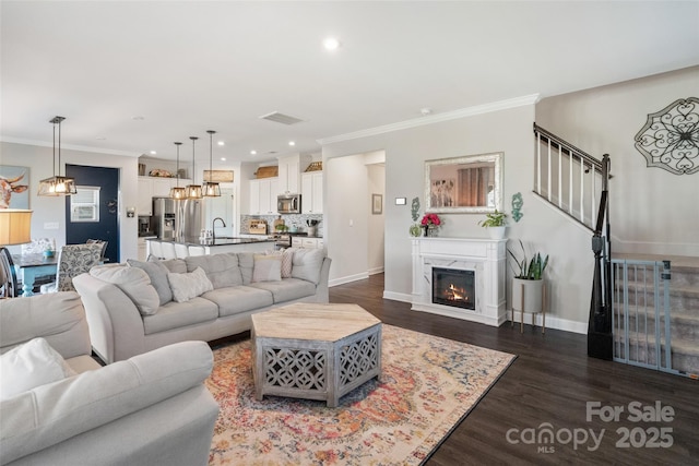 living room with ornamental molding, a chandelier, dark wood-style floors, recessed lighting, and baseboards