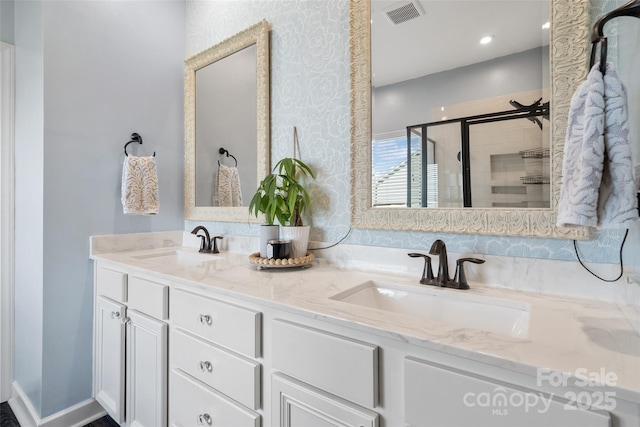 full bath featuring a stall shower, double vanity, and wallpapered walls
